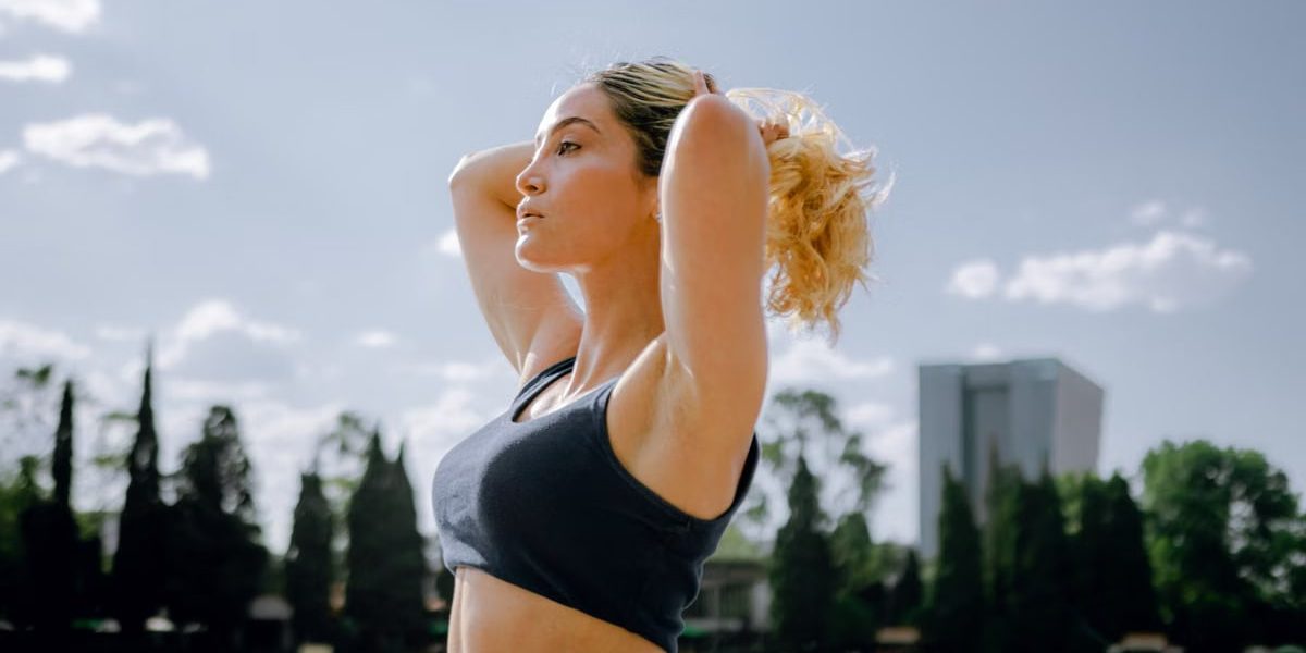 Fit woman in a black tank top enjoys a sunny workout outdoors in Ciudad de México, embracing wellness and healthy living.