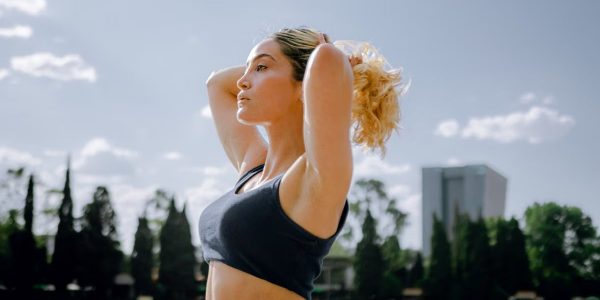 Fit woman in a black tank top enjoys a sunny workout outdoors in Ciudad de México, embracing wellness and healthy living.